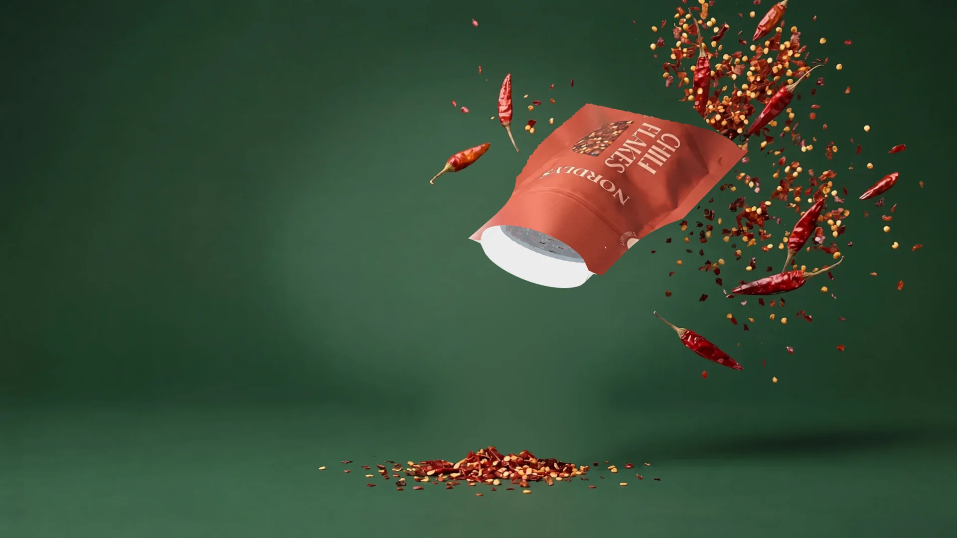 Chili flakes pouch tipped opening-down, chili sprinkling out through the Push&Dose membrane